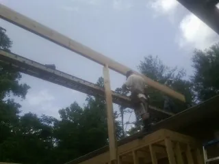 Carpenter setting a ridge beam over a new addition frame — Ice Dam Removal by Roofing Brothers in New Tazewell