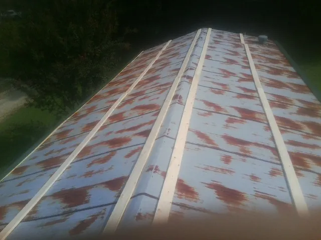 Rusted metal roof panels with new wood purlins before replacement — Storm Damage Roof Repair in New Tazewell by Roofing Brothers