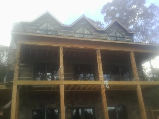 Dormers and porch framing on a large log home under construction — Roof Coating work by our crew in New Tazewell