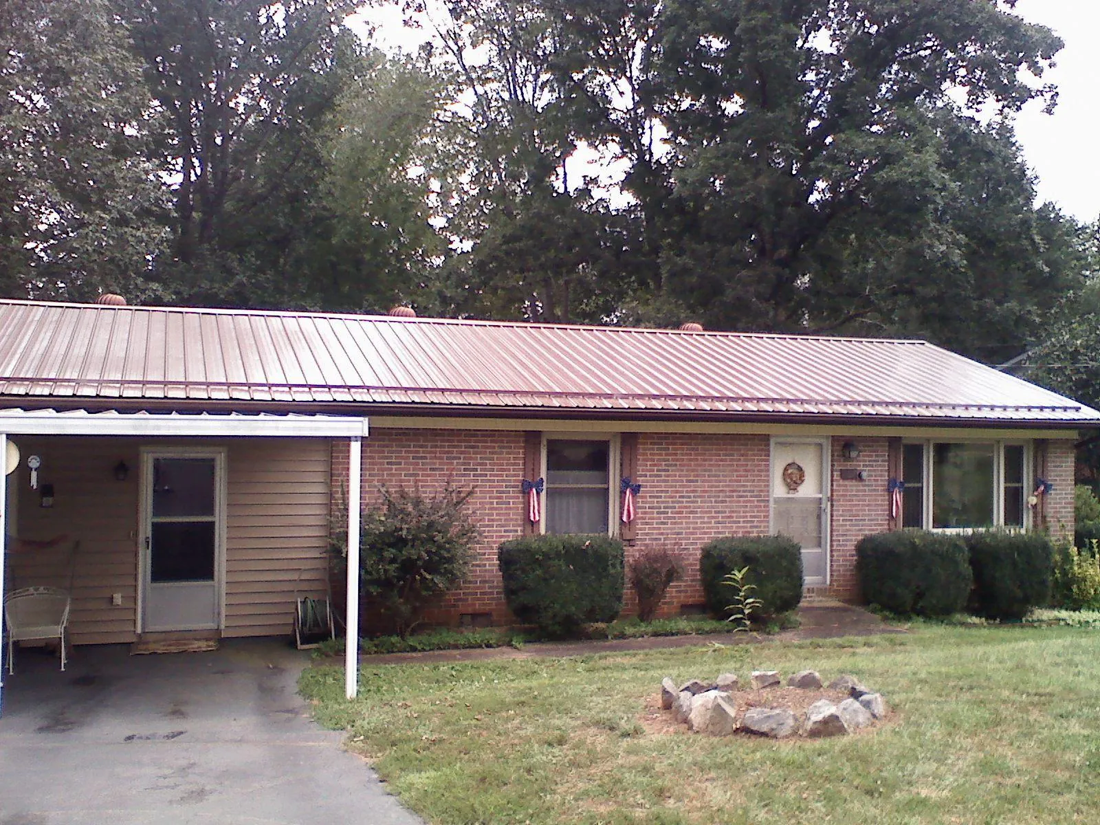 Bronze metal roof and carport on a brick ranch home — Roof Repair work by our crew in New Tazewell